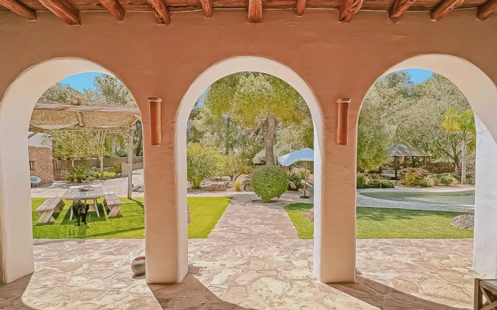 Arcos encalados con vistas al jardín y la piscina desde el porche, La Finca Agroturismo Can Bet