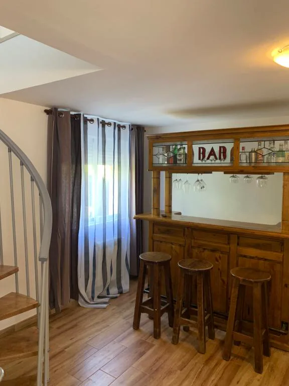 Salón con barra de bar y escalera de caracol