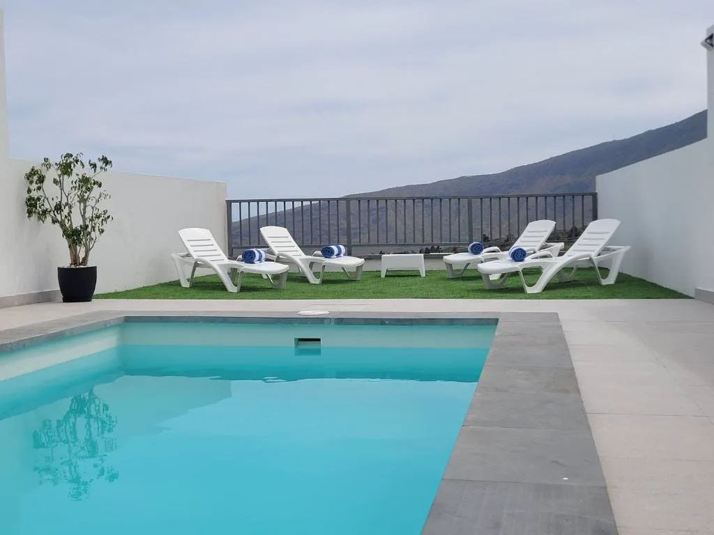 Piscina con tumbonas blancas y vistas al valle montañoso, La Kasita