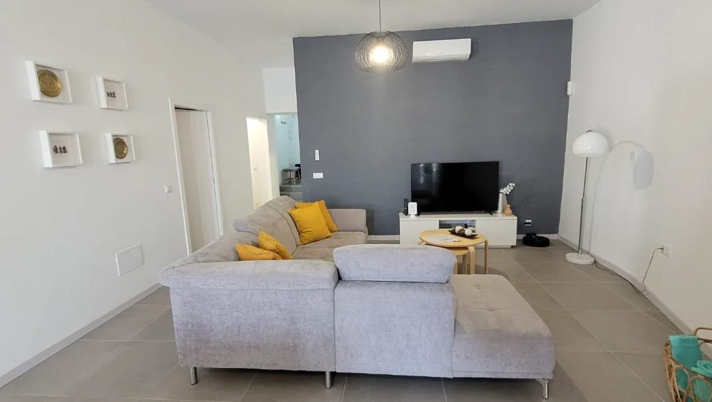 Salón con sofá gris y pared en tono antracita, La Kasita