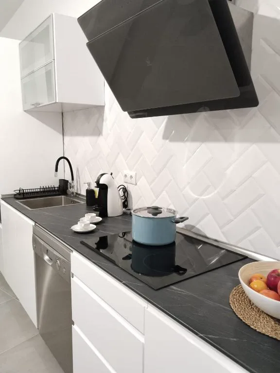 Cocina moderna con encimera de piedra oscura y campana de cocina negra, La Kasita