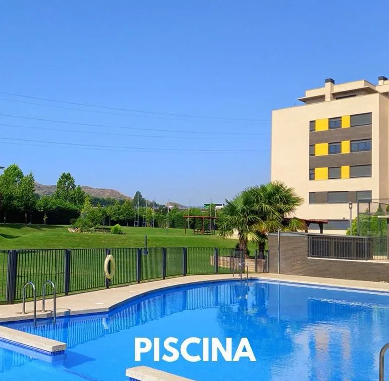 Piscina municipal iluminada de noche junto al apartamento
