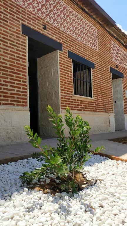 Fachada de ladrillo visto con pequeño jardín de grava