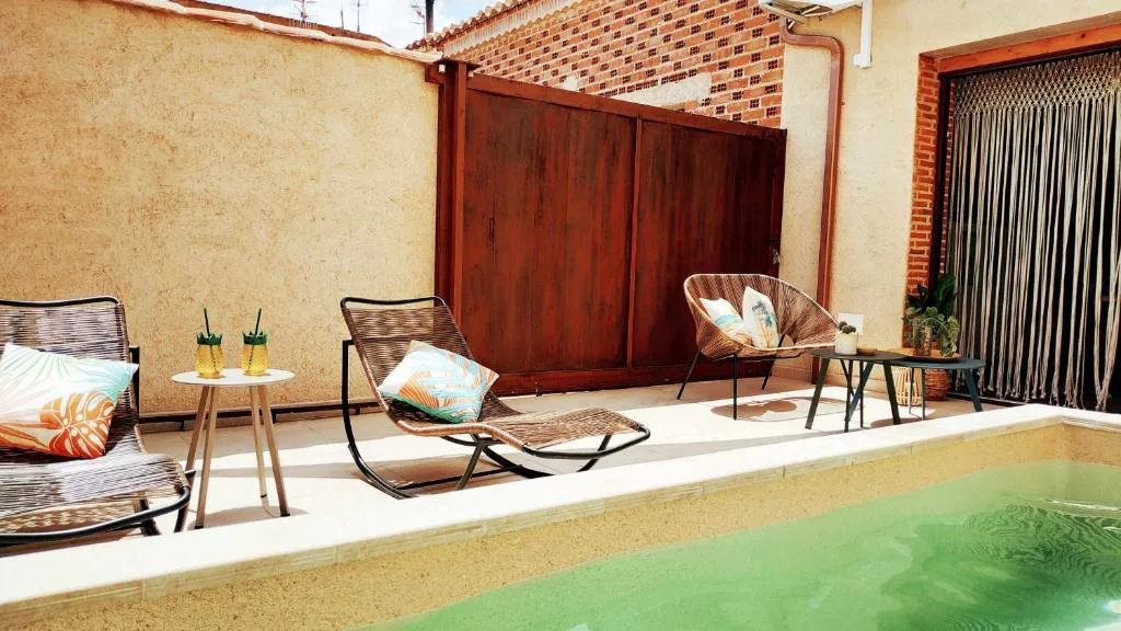 Patio con piscina, tumbonas y cortina de madera