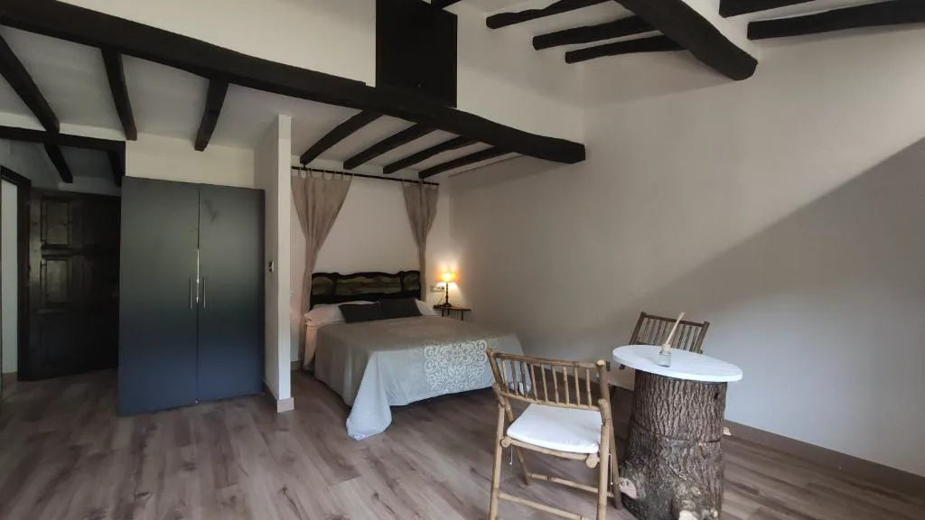 Habitación con cama de dosel y vigas de madera