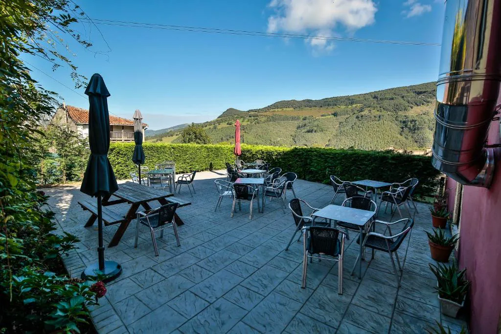 Terraza de losa con mesas y vistas al valle