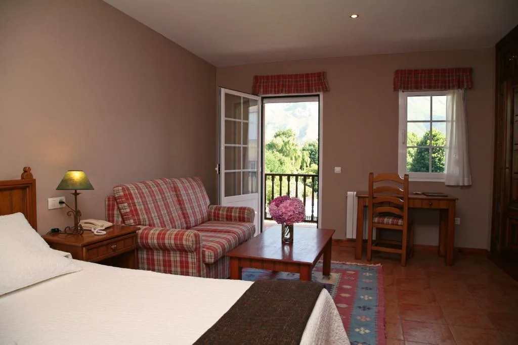 Habitación con puerta al balcón y sillón de cuadros