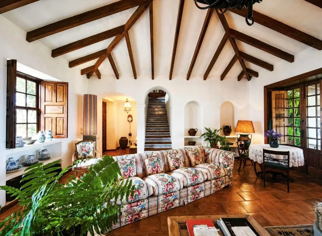 Salón con escalera de azulejos tradicionales y sofá de estampado floral, La Rayuela Suites Boutique