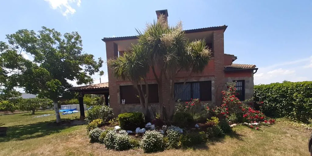 Piscina pequeña con césped junto a la casa