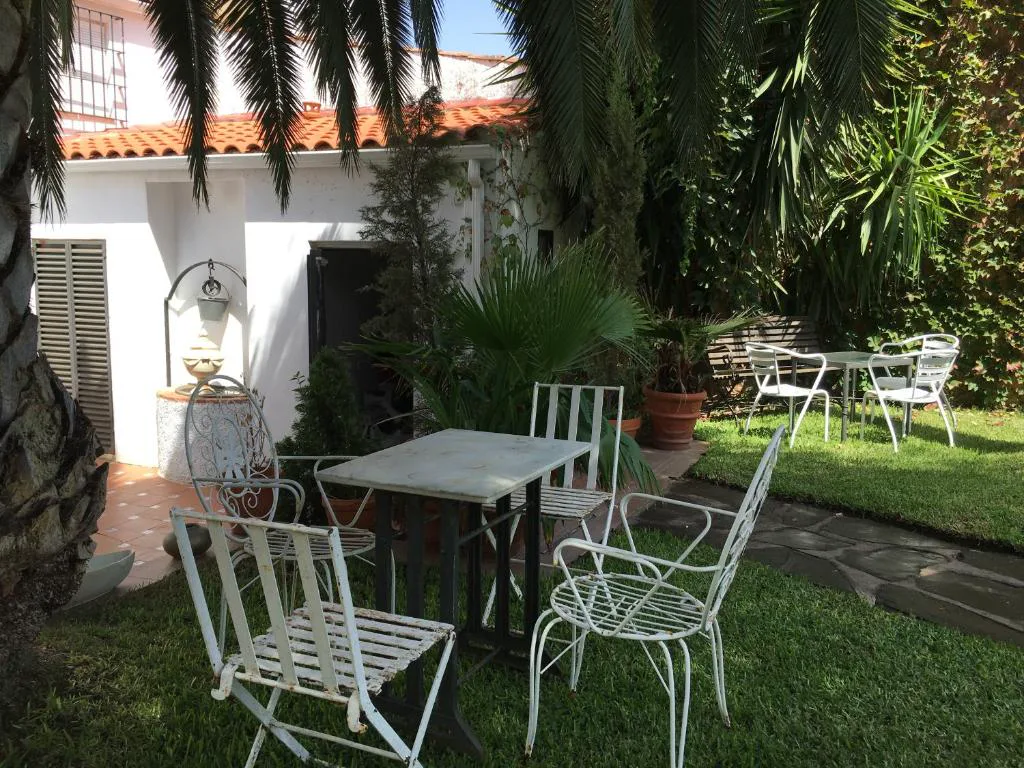 Jardín con mesa y sillas blancas
