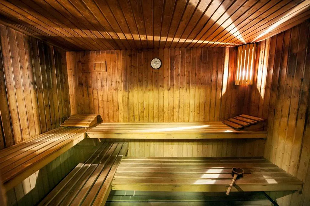 Sauna de madera vacía con luz cálida entrando por la ventana, Laias Caldaria