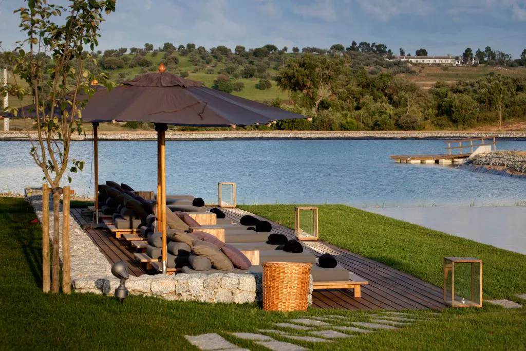 Zona chill-out junto al lago con sombrillas y cojines al atardecer, L'AND Vineyards