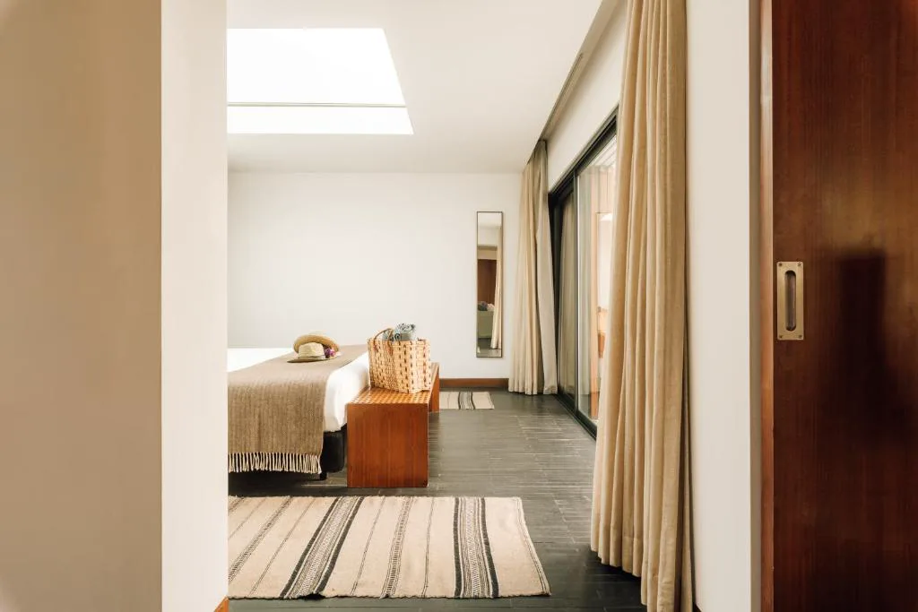 Dormitorio con claraboya y suelo de madera oscura de una suite de L'AND Vineyards