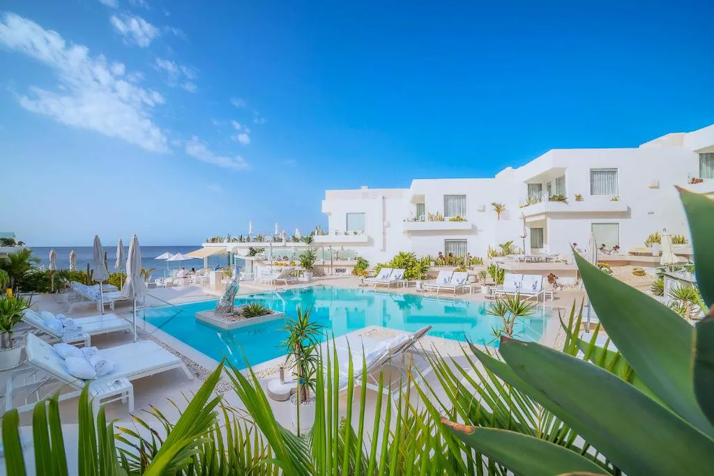 Piscina principal frente al Atlántico con tumbonas blancas, Lani's Suites de Luxe