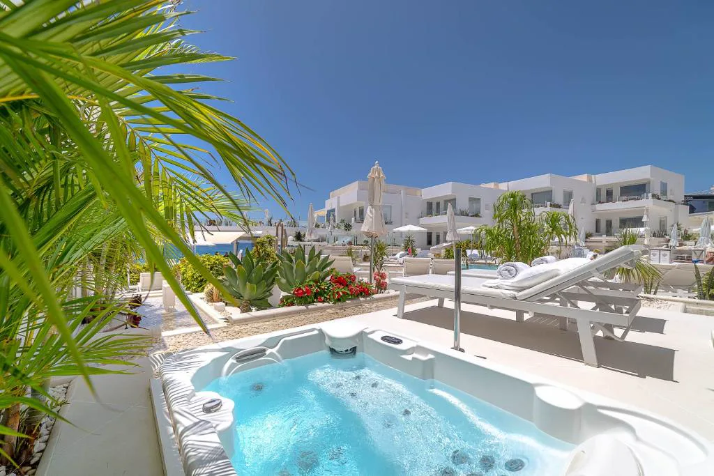 Jacuzzi privado en terraza con vistas al complejo de villas blancas, Lani's Suites de Luxe