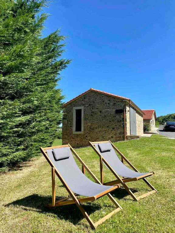 Dos hamacas de madera frente a la casa de piedra restaurada, Lar do Gado