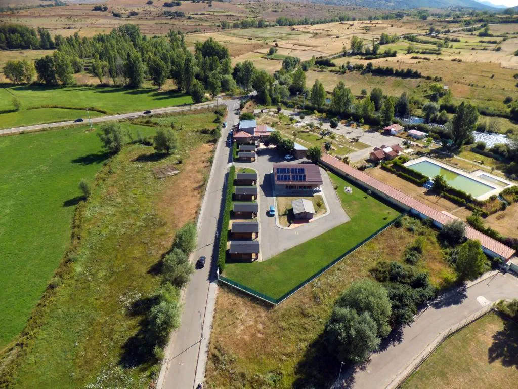 Vista aérea del conjunto de cabañas entre campos y arbolado