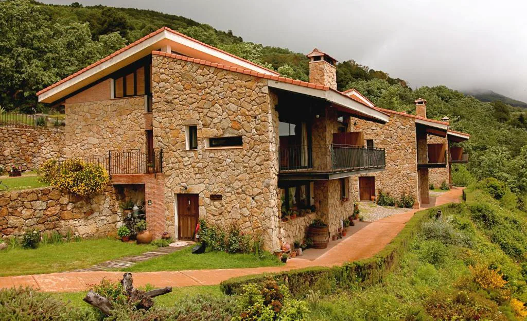 Casa de piedra con balcones entre montañas verdes