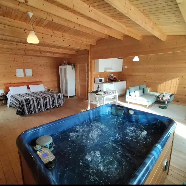 Jacuzzi azul en una cabaña de madera con cama grande