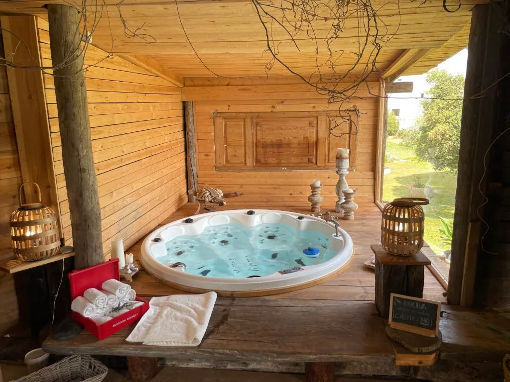 Jacuzzi redondo en una cabaña de madera con velas
