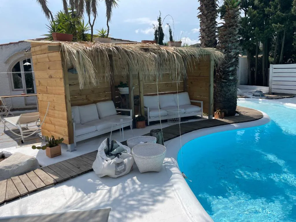 Zona de descanso con techo de paja junto a la piscina