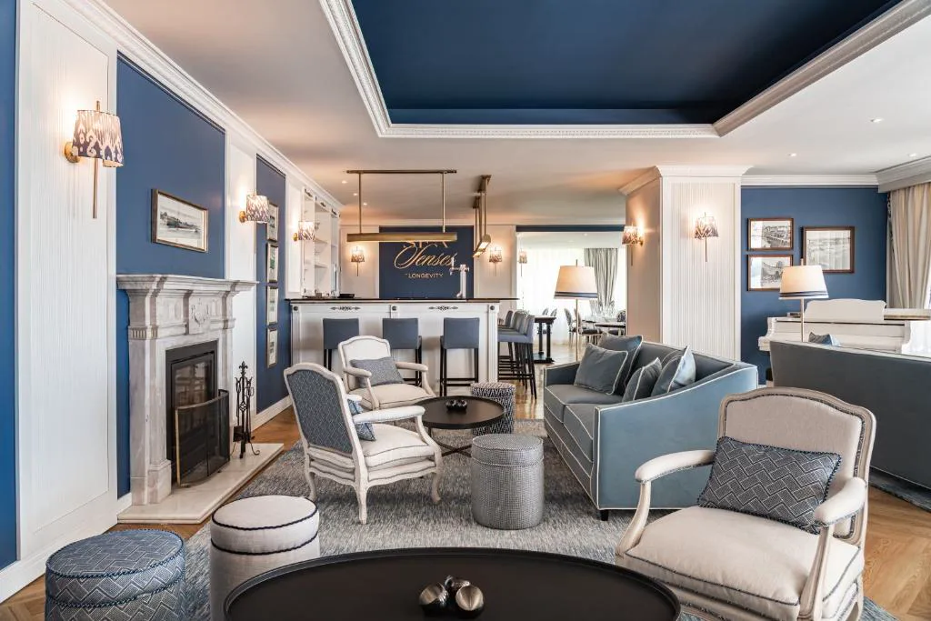 Salón bar en azul marino junto a la chimenea de mármol, Longevity Senses