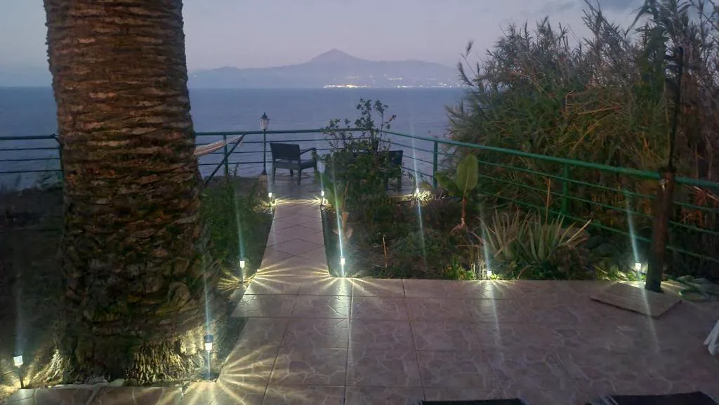 Vista nocturna de la terraza iluminada con el Teide silueteado al otro lado del Atlántico, Los Cerrajones