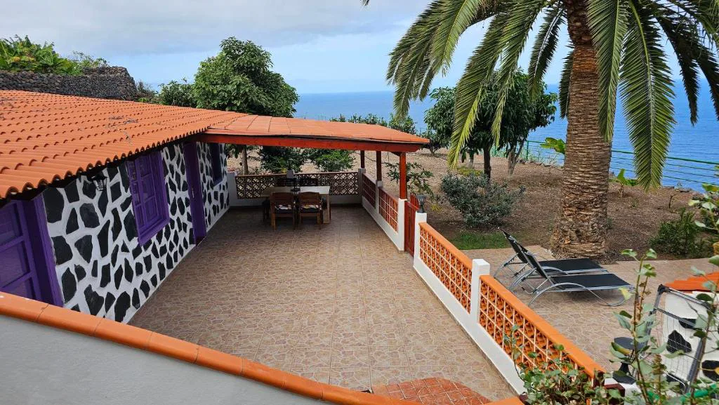 Camino con farola y palmera hacia la terraza con vistas al mar, Los Cerrajones