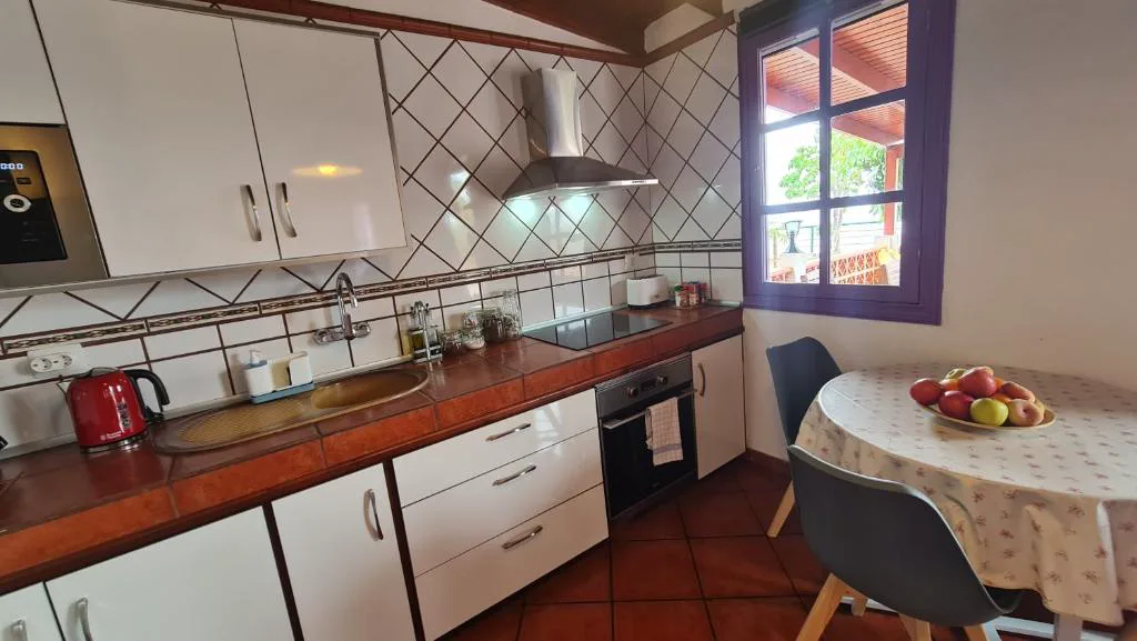 Cocina blanca con azulejos de rombos y mesa con frutero, Los Cerrajones