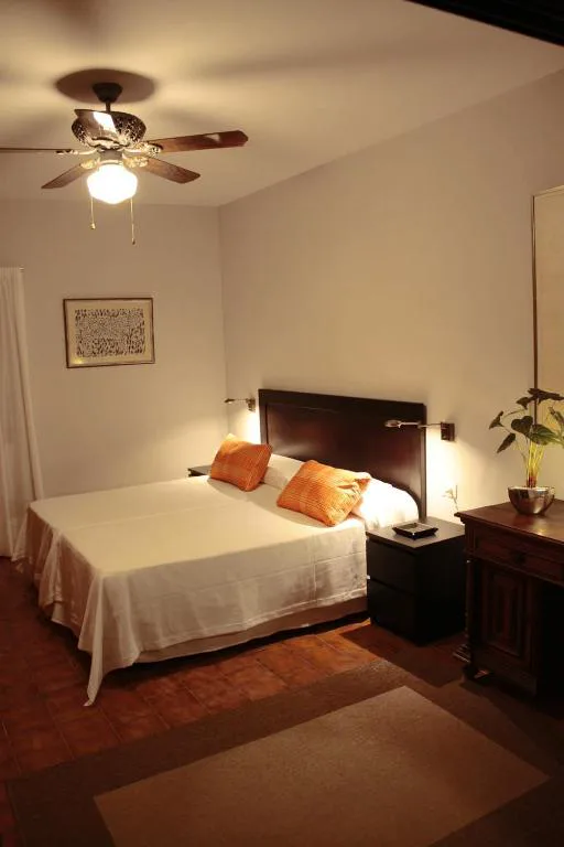 Dormitorio con ventilador de techo y cojines naranjas, Los Fondos