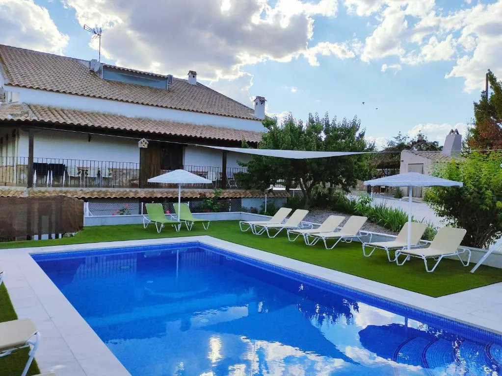 Piscina rectangular junto a una casa de dos plantas