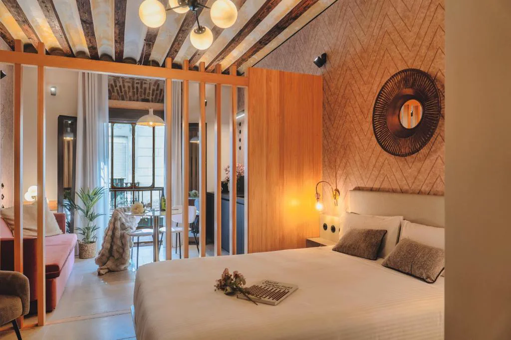 Habitación con cama blanca y pared de madera