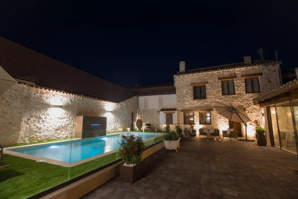 Piscina iluminada de noche en el patio de la casa
