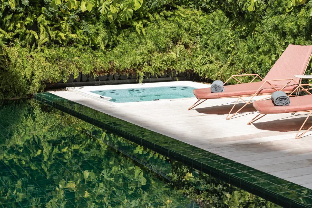 Jacuzzi entre jardín vertical y piscina en LUSTER Hotel, Lisboa