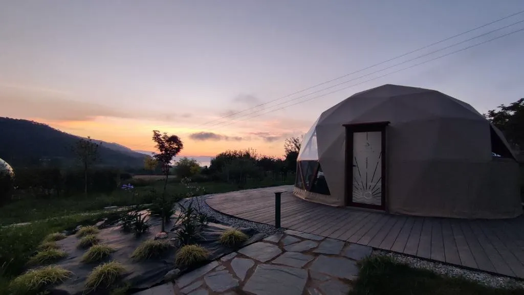 Cúpula geodésica de Luzada Glamping iluminada al atardecer, con vistas al valle de Xove