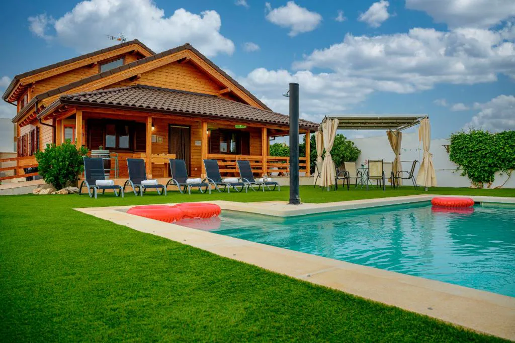 Piscina rectangular delante de una casa de madera