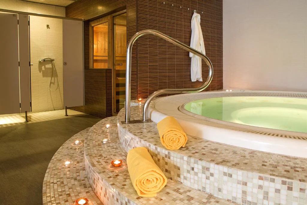Jacuzzi con mosaico y albornoz en el spa