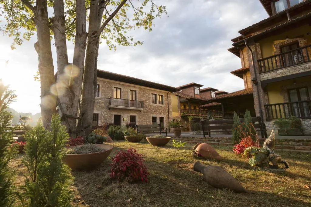 Jardín y fachada de piedra del hotel al atardecer, entorno rural de Onís, Asturias