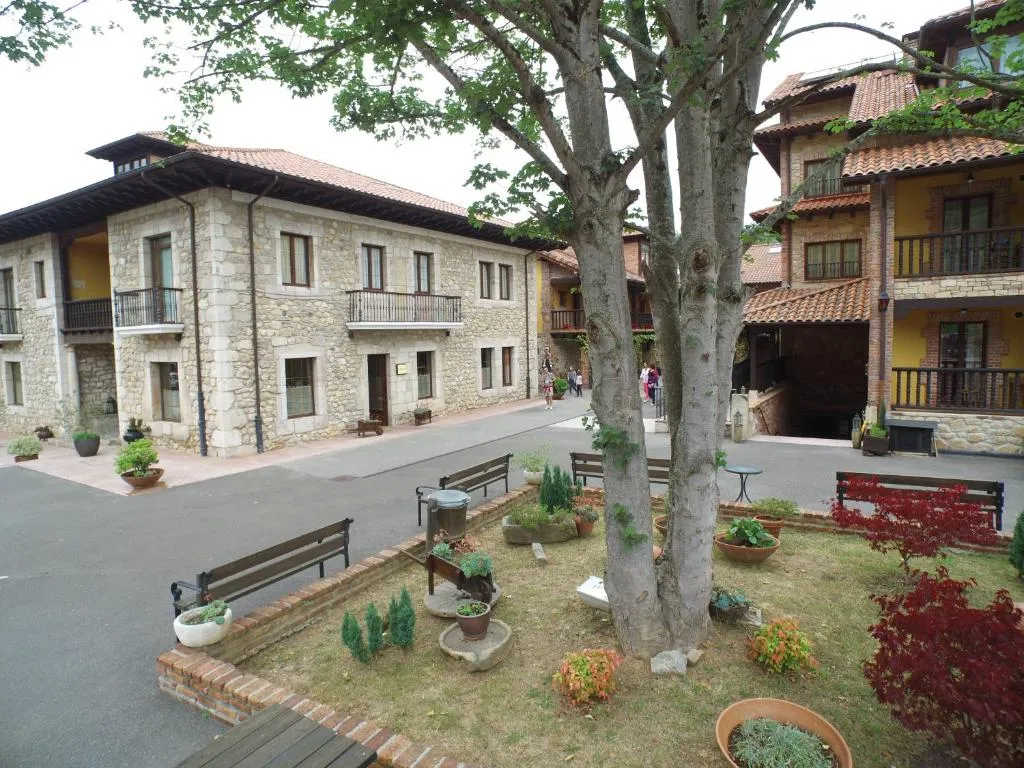 Plaza empedrada del pueblo junto al hotel, con bancos y jardineras