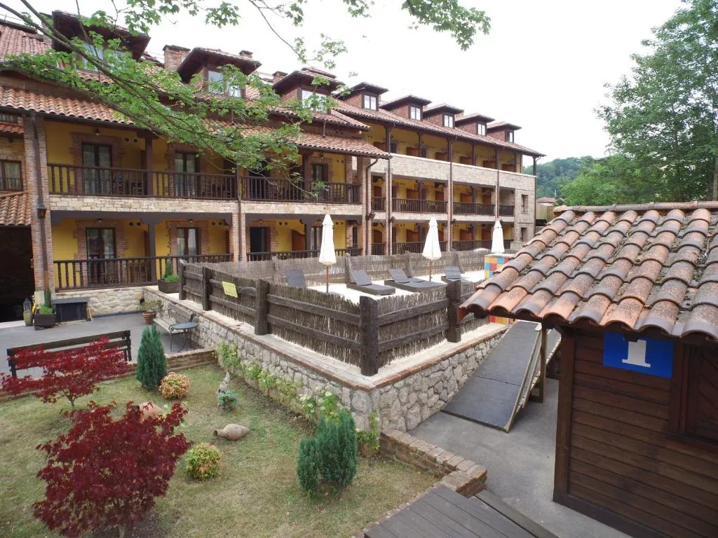 Terraza exterior de las habitaciones con tumbonas frente al tejado tradicional asturiano