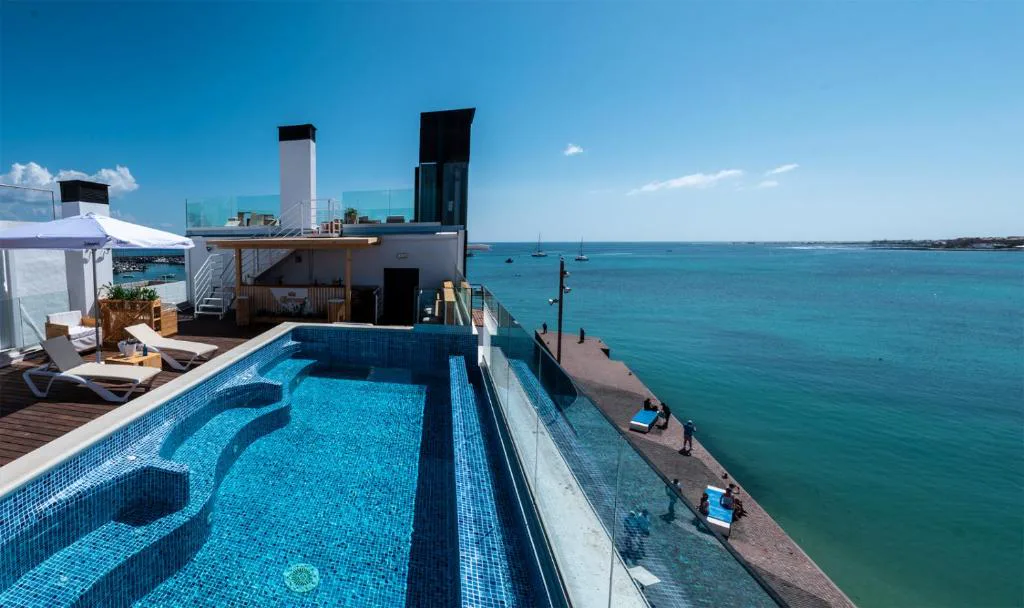 Piscina infinita en la azotea de Hotel Boutique La Marquesina con vistas al mar y a Lanzarote, en Corralejo, Fuerteventura