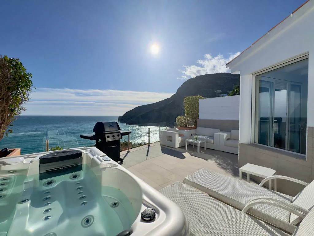 Jacuzzi en una terraza blanca con vistas al mar en Calpe