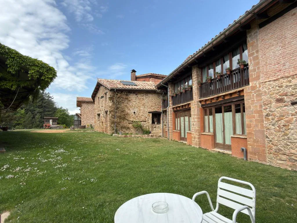 Masía de piedra con jardín y mesa blanca