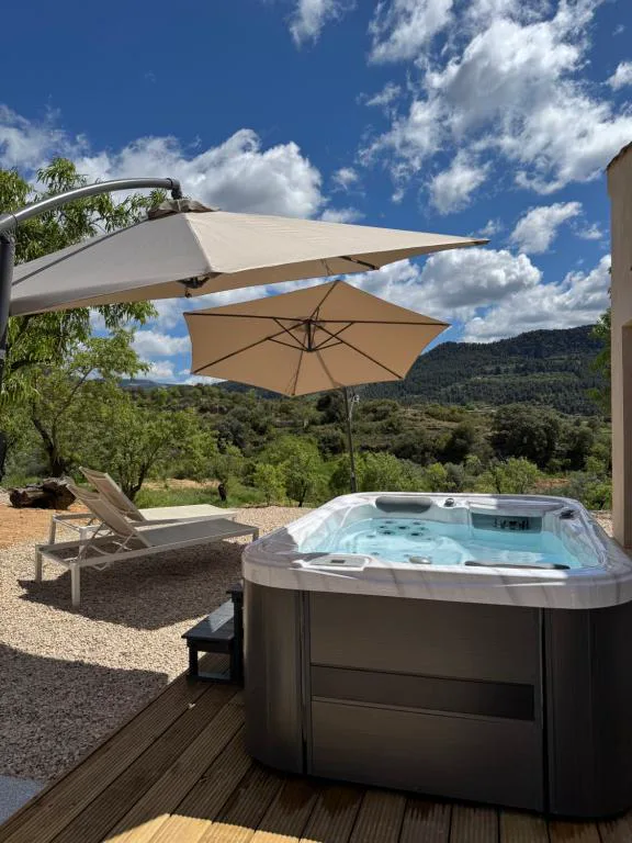 Jacuzzi exterior con sombrilla junto a una terraza