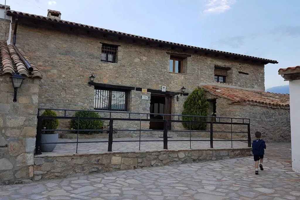 Masía de piedra con balcón y patio de piedra