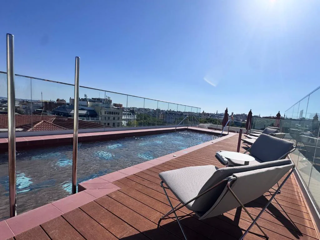 Piscina de la azotea con tumbonas y vistas a los tejados de Madrid