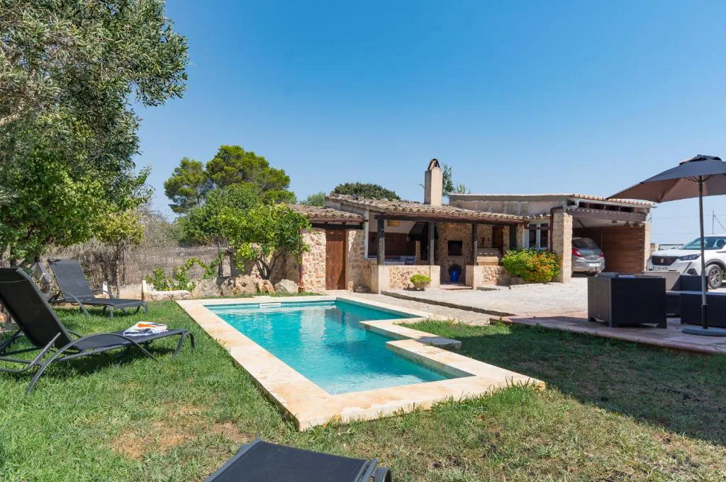 Piscina con tumbonas y jardín de olivos junto a la casa de piedra, Molí D'en Barret