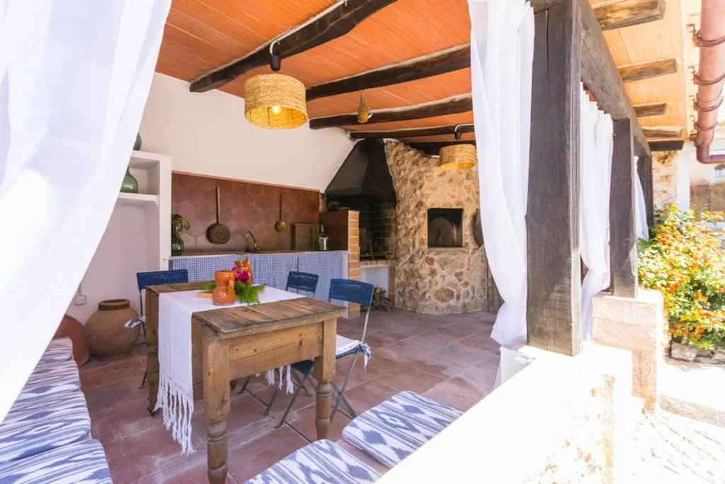 Terraza cubierta con horno de leña de piedra y mesa de comedor rústica, Molí D'en Barret