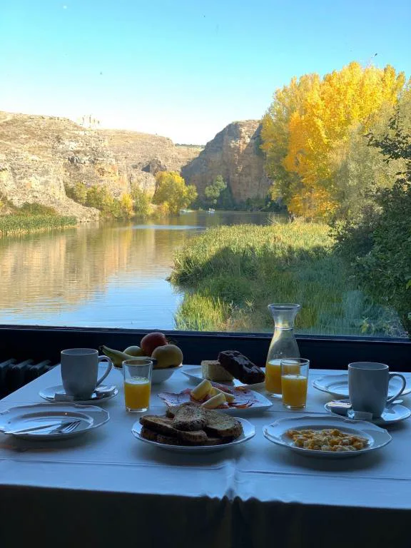 Desayuno servido junto a una ventana con vistas al río