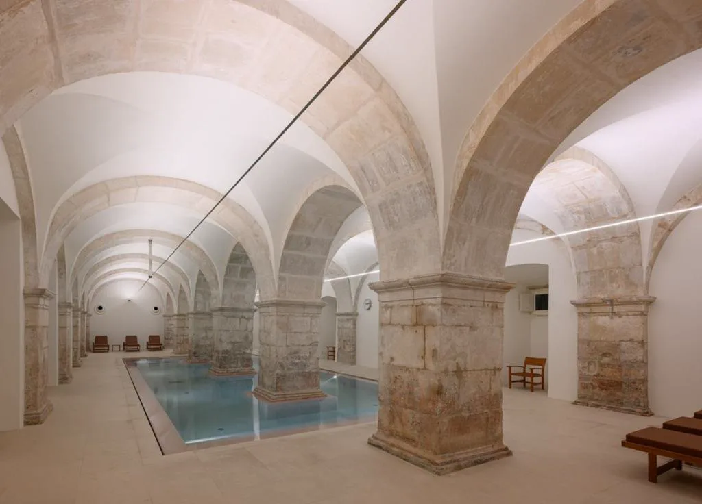 Piscina cubierta bajo las bóvedas de piedra originales del Claustro do Rachadouro, Montebelo Mosteiro de Alcobaça